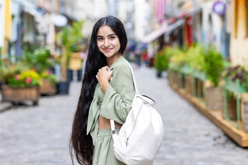 woman with long hair standing in the street