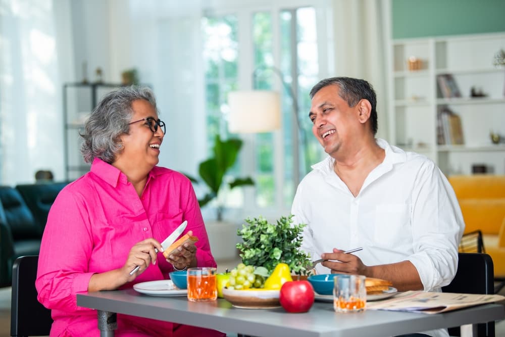 Happy elderly couple eating breakfast