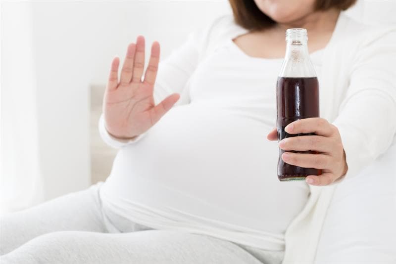 Pregnant woman holding drink